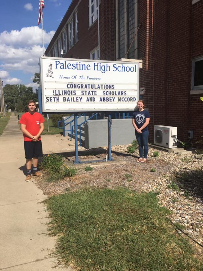 Seth Bailey and Abbey McCord, 2019 Illinois State Scholars, pose in front of the school sign announcing their awards.