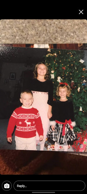 Chance Wilber and his two siblings standing in front of their Christmas tree as kids.