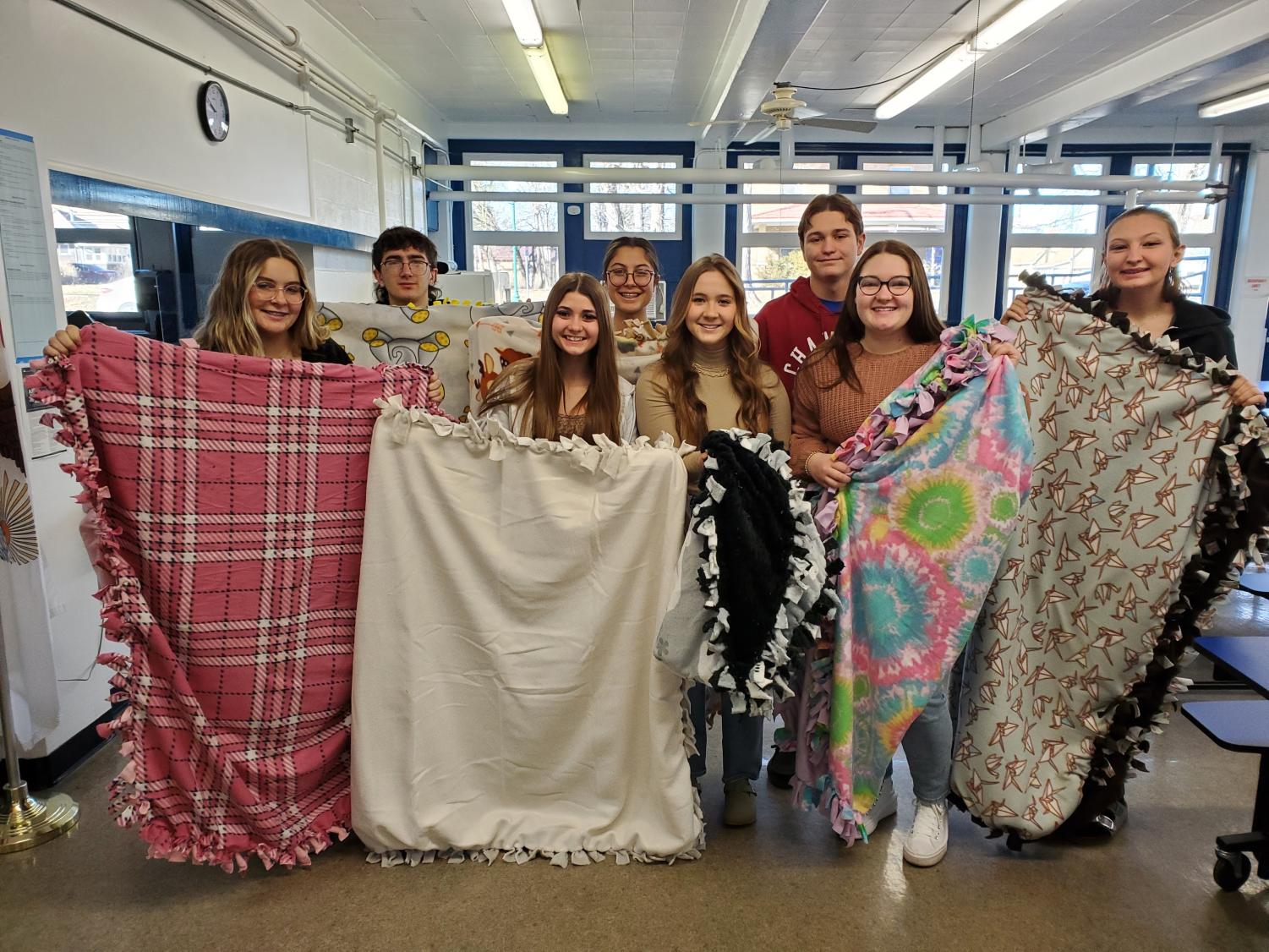 Members holding the blankets that were donated to the Health Department