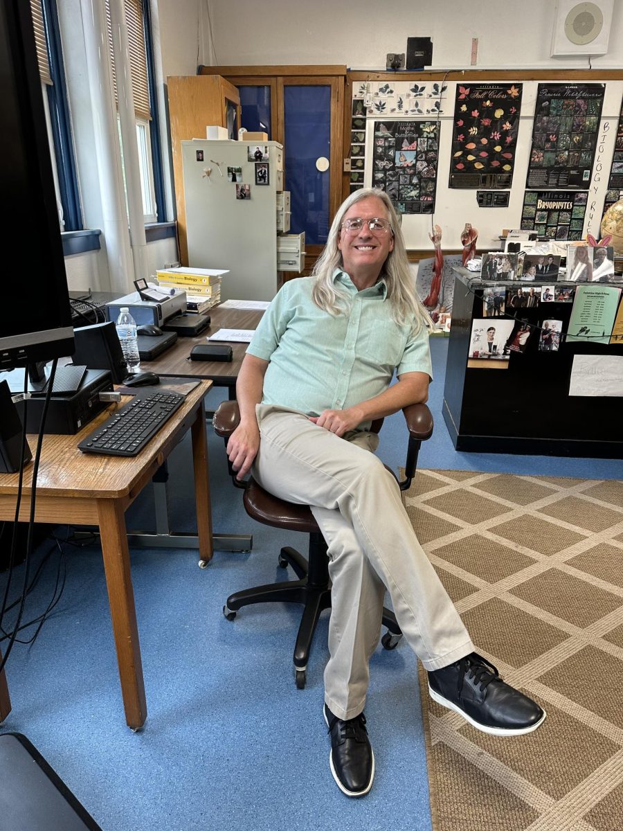 Mr. Smith, sitting in his classic chair in his Biology room. 