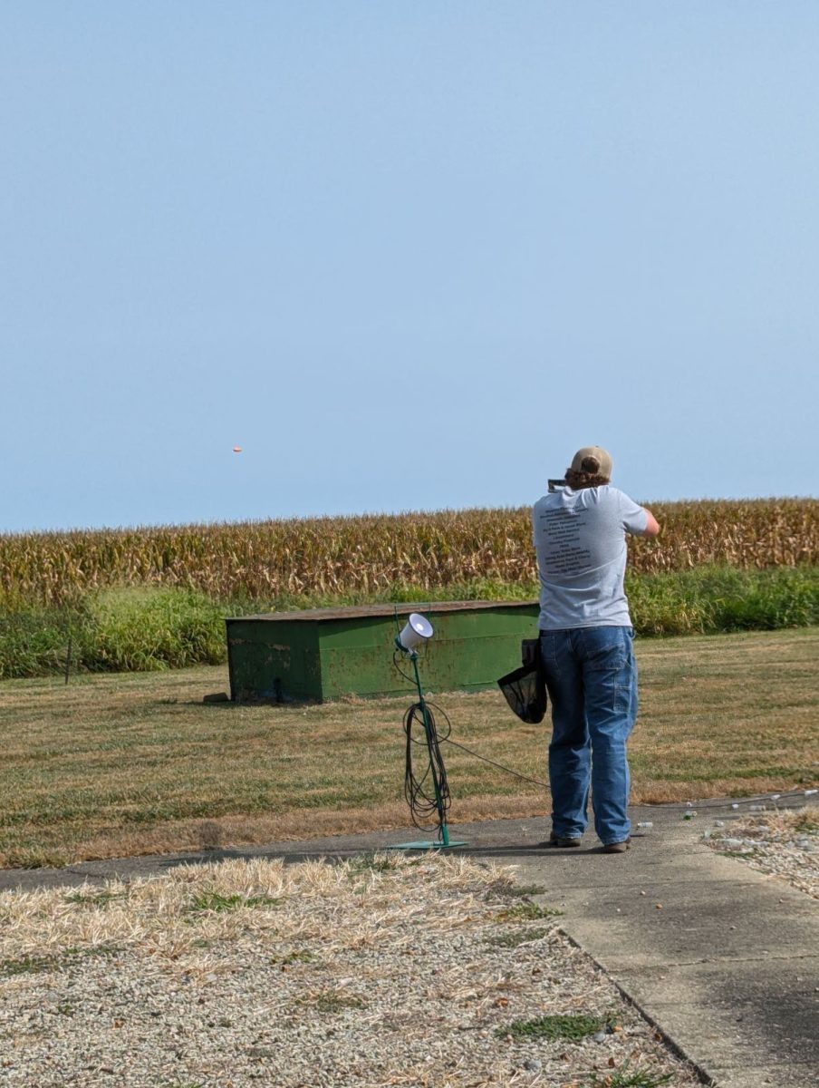 Shawn aiming at a clay pigeon getting ready to break it.